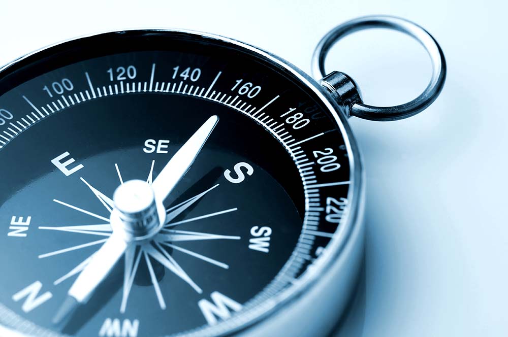 zilver kompas met zwart-wit kompasroos tegen witte achtergrond
