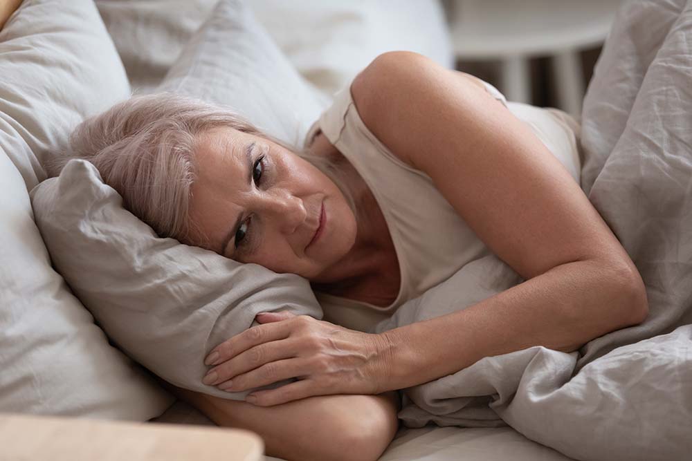 Senior vrouw in bed wakker